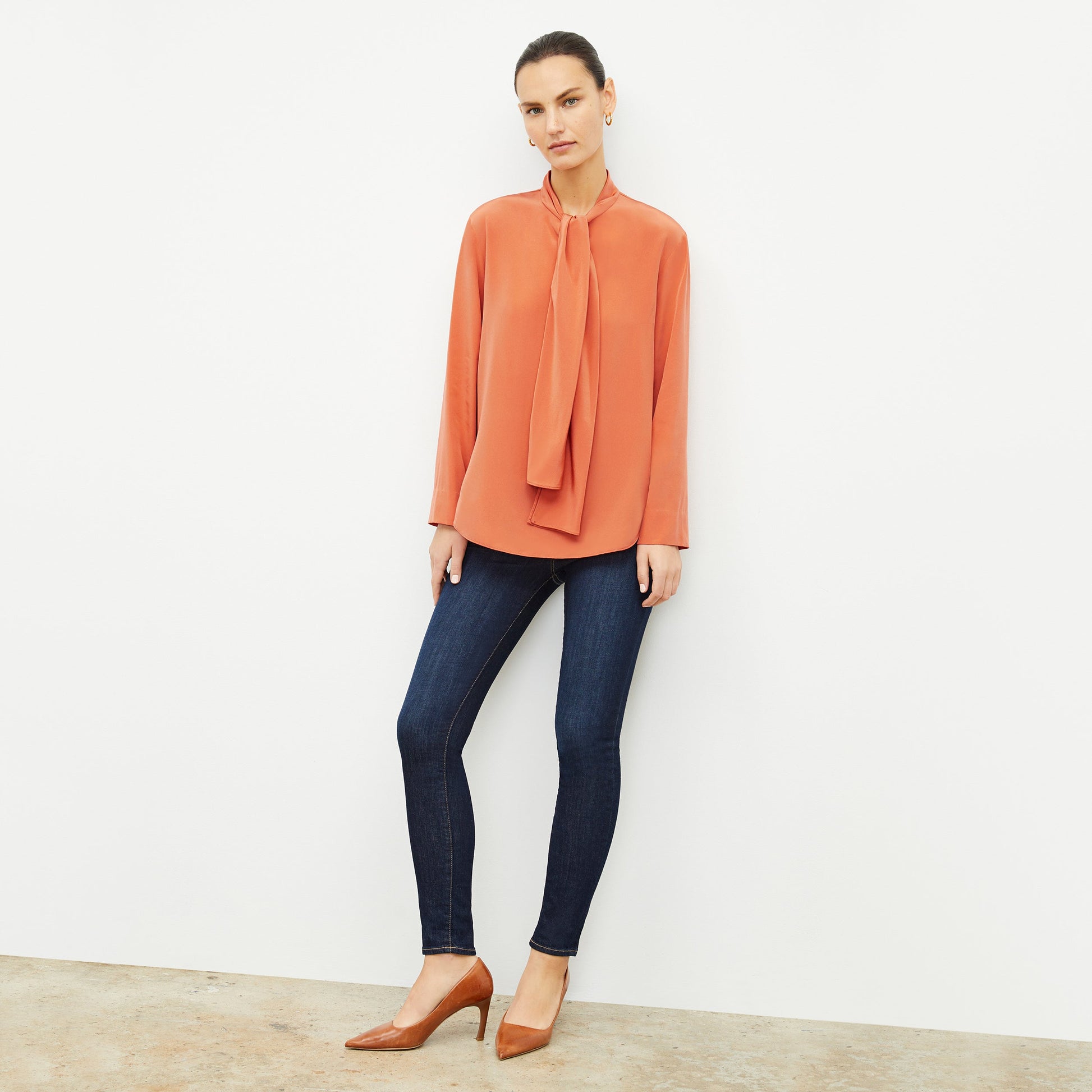 Front image of a woman wearing the Darcy Top in Guava | Lead